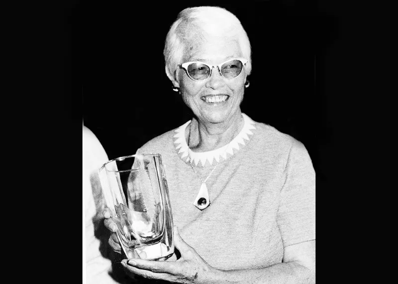 a black and white photo of a woman holding a glass award