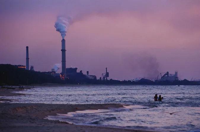 Swimmers brave the waters in the shadow of a coal-fired power plant. Coal plants like this one emit CO2 into our atmosphere which is warming the planet and altering the chemistry of the ocean.