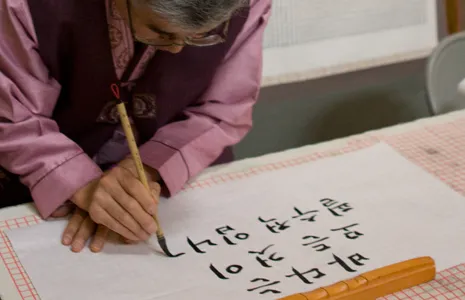 A photo of calligrapher Myoung-Won Kwon writing an ocean-themed message. 