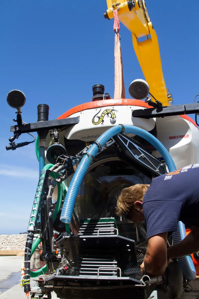 Submarine pilot Bruce Brandt secures ARMS to the outside of the submersible Curasub so it can deploy ARMS on the seafloor.