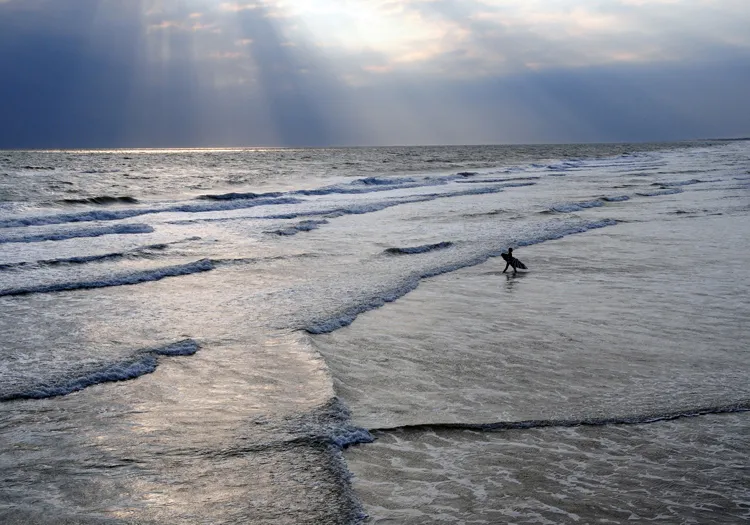 A surfer waits for the perfect wave.