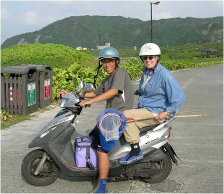 Curator and Research Scientist Lynne Parenti with student Shao-i Wang on a moped with fish collection gear