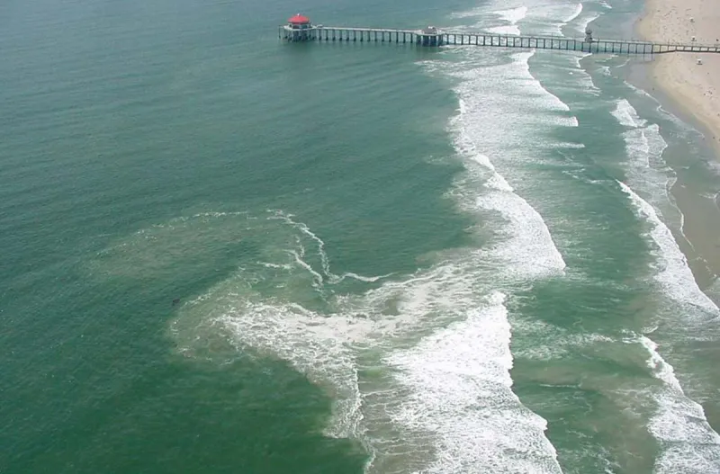 a rip current along a beach with a pier
