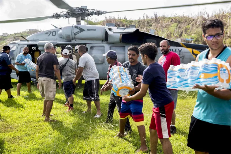 Aftermath Volunteers unloading water from helicopter