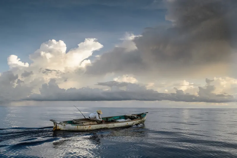 A Honduran small-scale fisherman on a boat setting out to fish. 