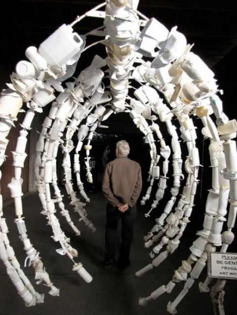 A whalebone rib cage replica made from empty white bottles. 