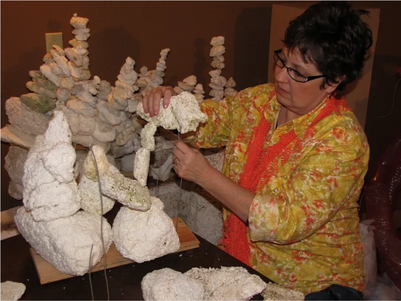 A volunteer puts together the bleached coral reef by stacking pieces of Styrofoam onto wire.