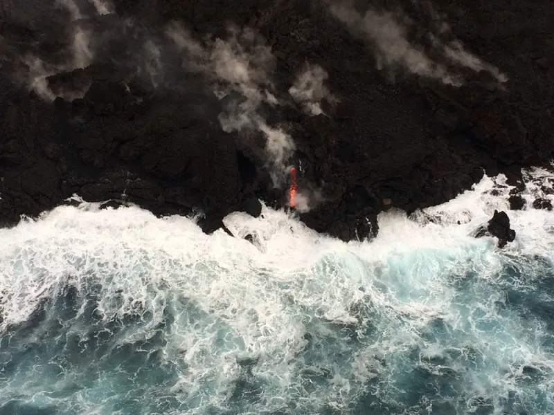 An aerial view of the Hawaii's shore with lava flowing into the ocean from Kilauea volcano.