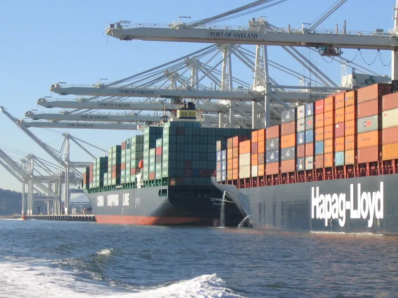 Large container ships at port, discharging ballast water in the Port of Oakland