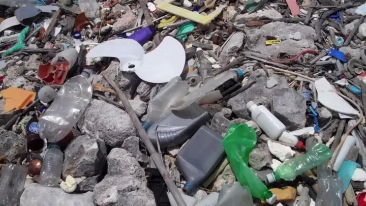 Plastic bottles and other marine debris cover a rocky beach in Curacao.