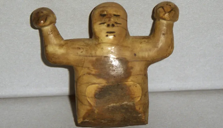 This ivory sculpture from Point Barrow, Alaska, represents Kikámigo, a guardian spirit, holding a whale in each hand.