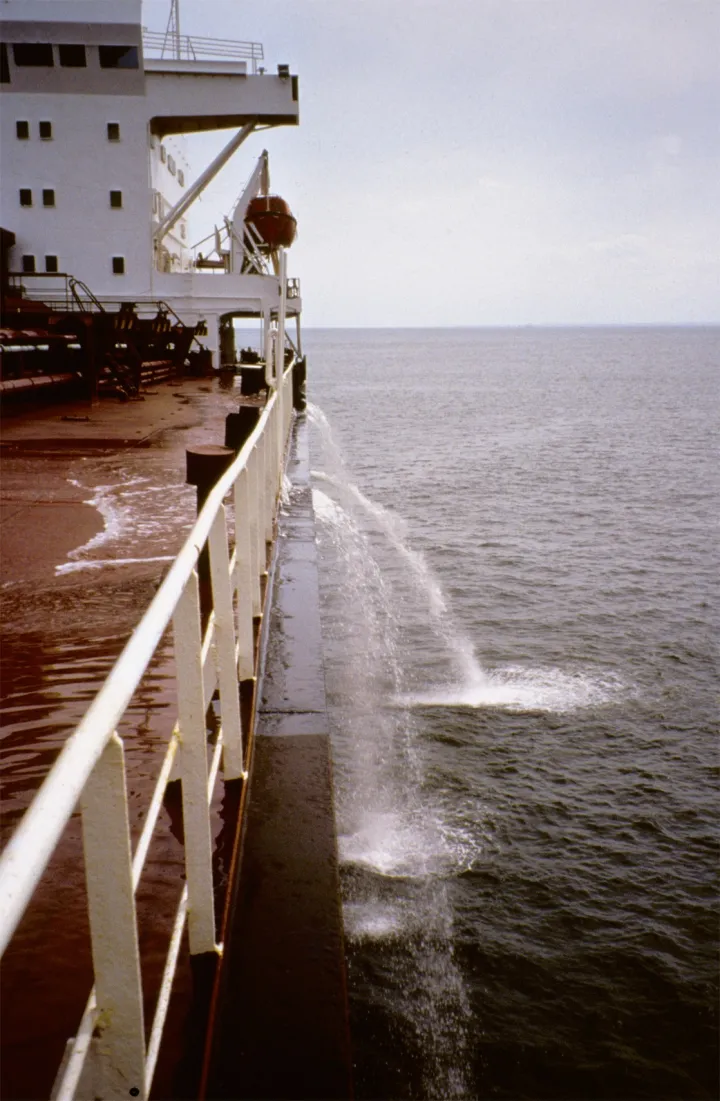 A large ship flushes water from its ballast tanks while at sea