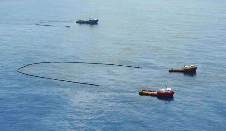 boats sweeping up the oil slick