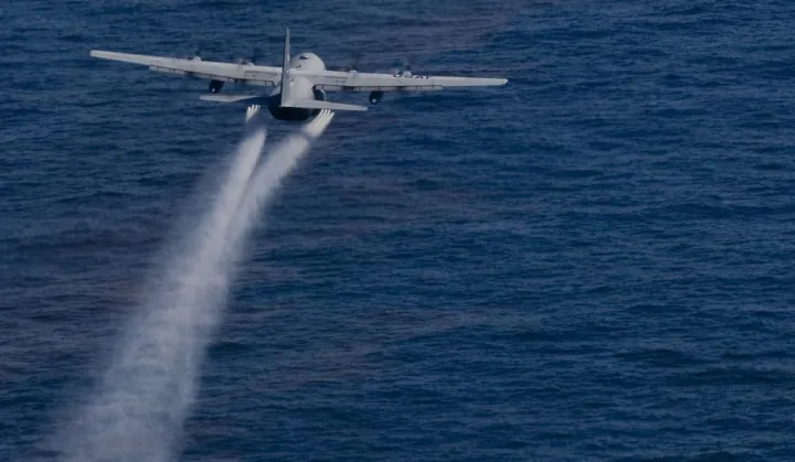 A jet drops dispersant onto the Gulf oil slick.