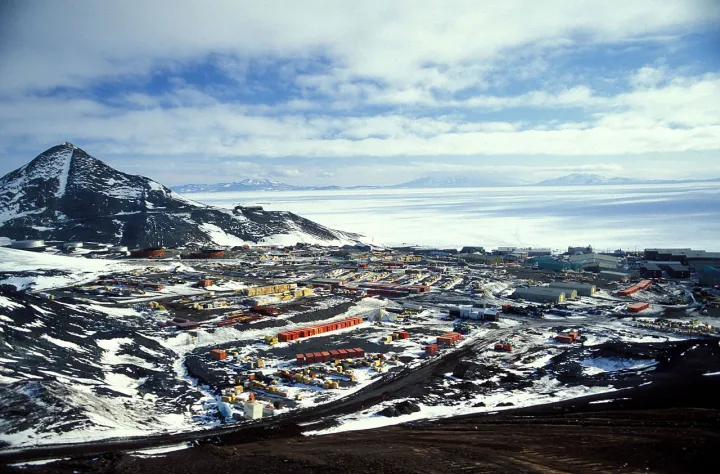 A view of McMurdo Station with a frozen Ross Sea in the background.