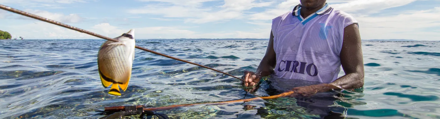 a spear fisher with a speared tropical fish
