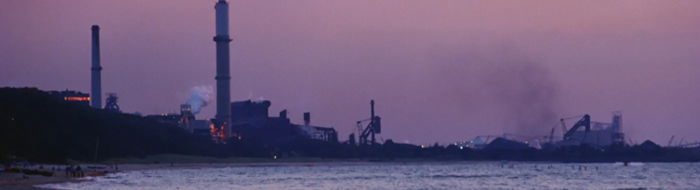Swimmers brave the waters in the shadow of a coal-fired power plant.  Coal plants like this one emit CO2 into our atmosphere which is warming the planet and altering the chemistry of the ocean.
