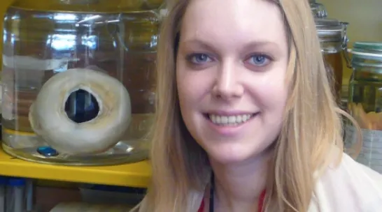 Hannah Waters with preserved giant squid eye next to her.