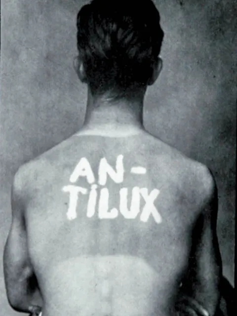 a man's back with words "antilux" written on it