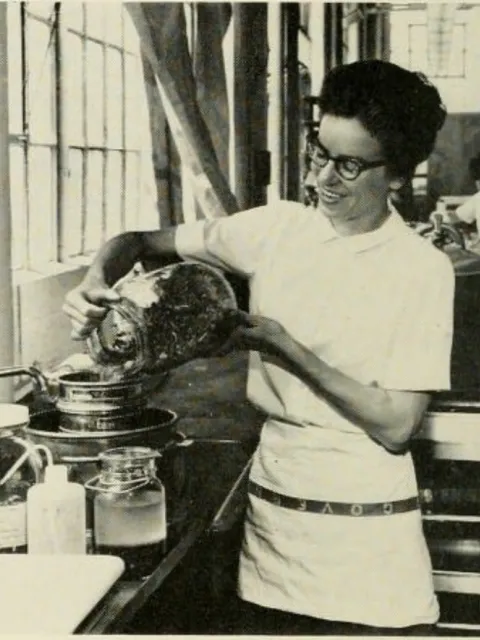 a woman pours a sample into a jar